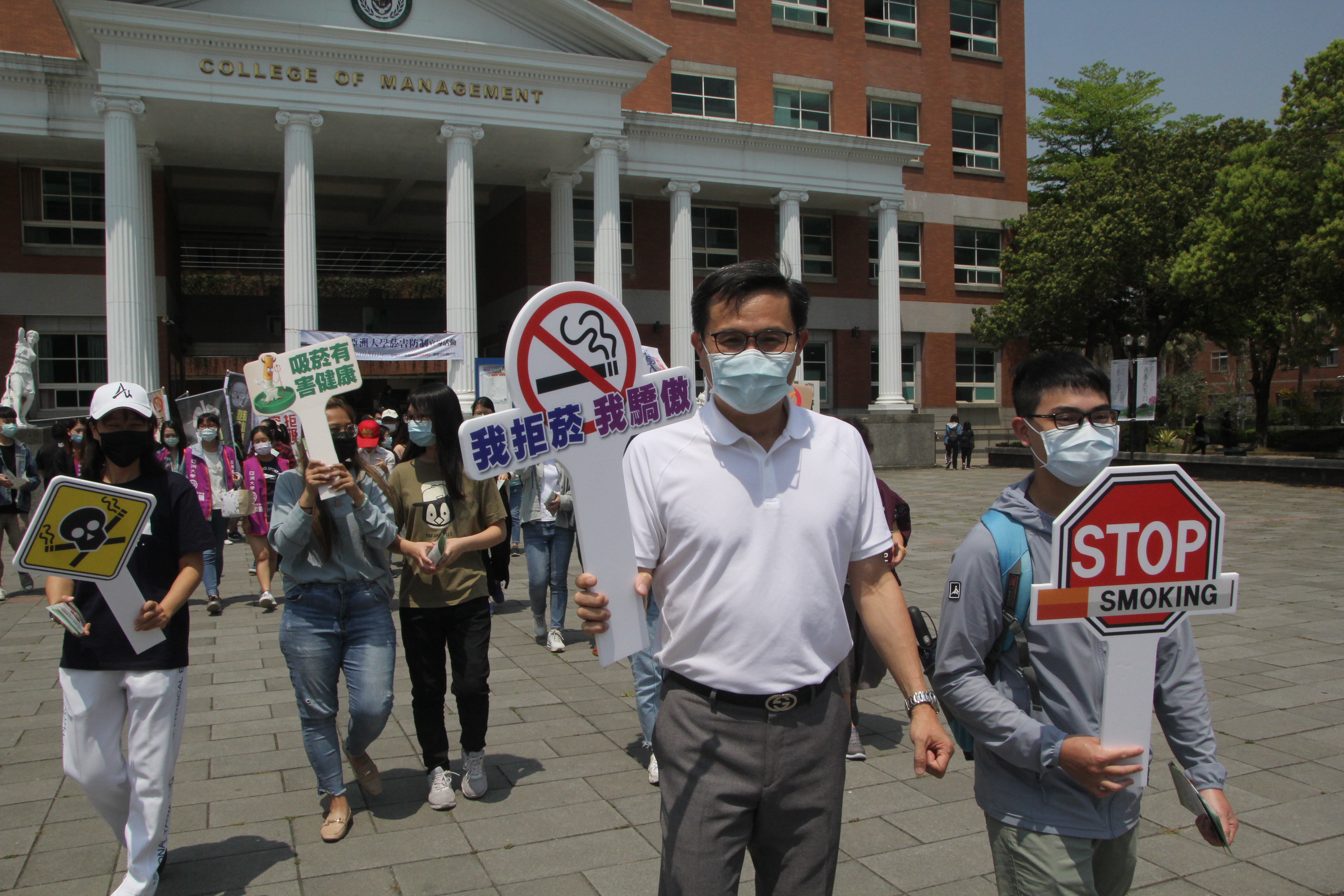 張少樑學務長(前排左)帶領出席「我拒菸，我驕傲」活動成員，到學校餐廳等處廣發拒菸文宣。