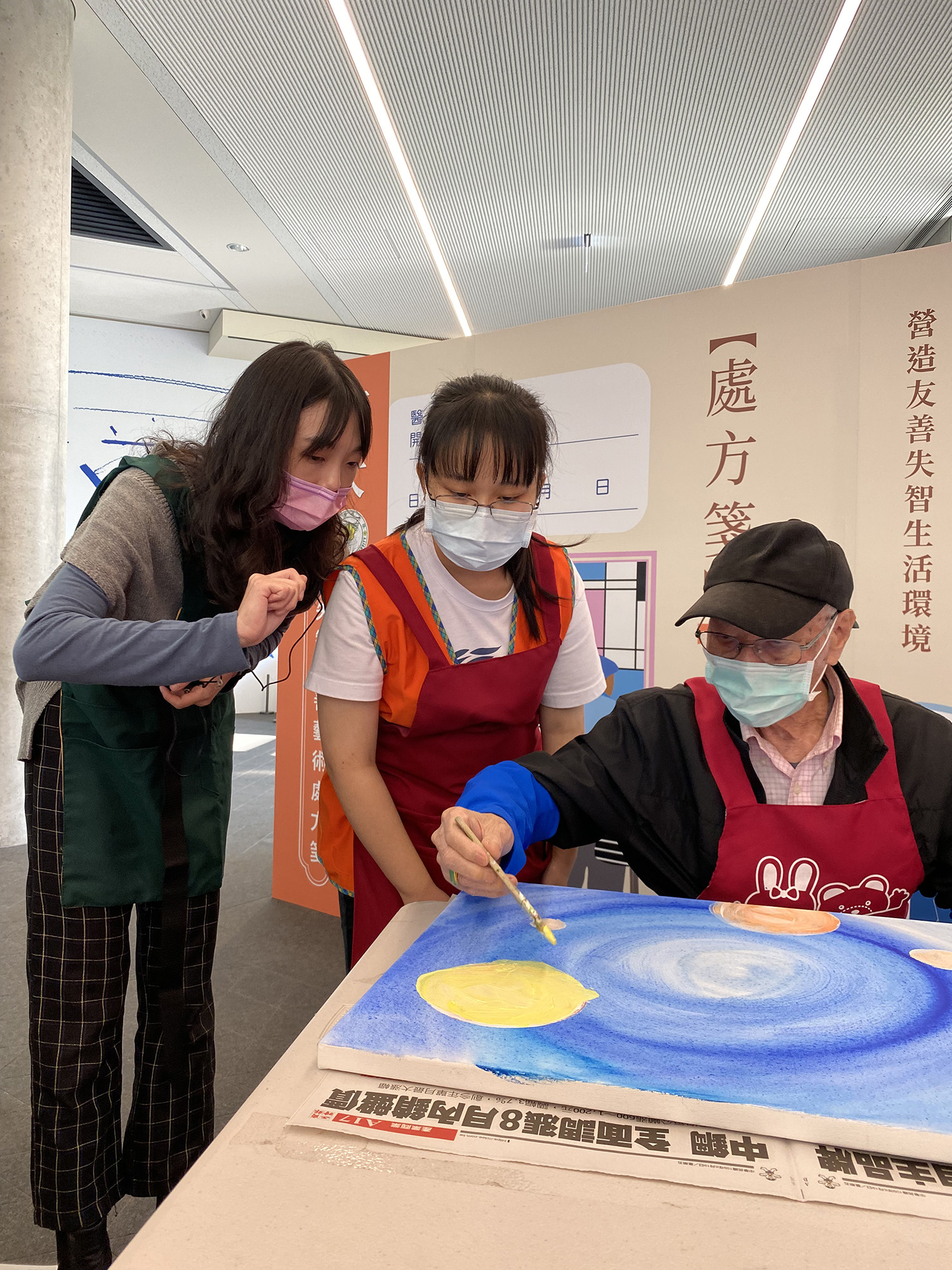 「金色博士Dr. Golden音樂生活創意中心」講師(左)，與亞大護理系學生，協助長輩畫出心中色彩