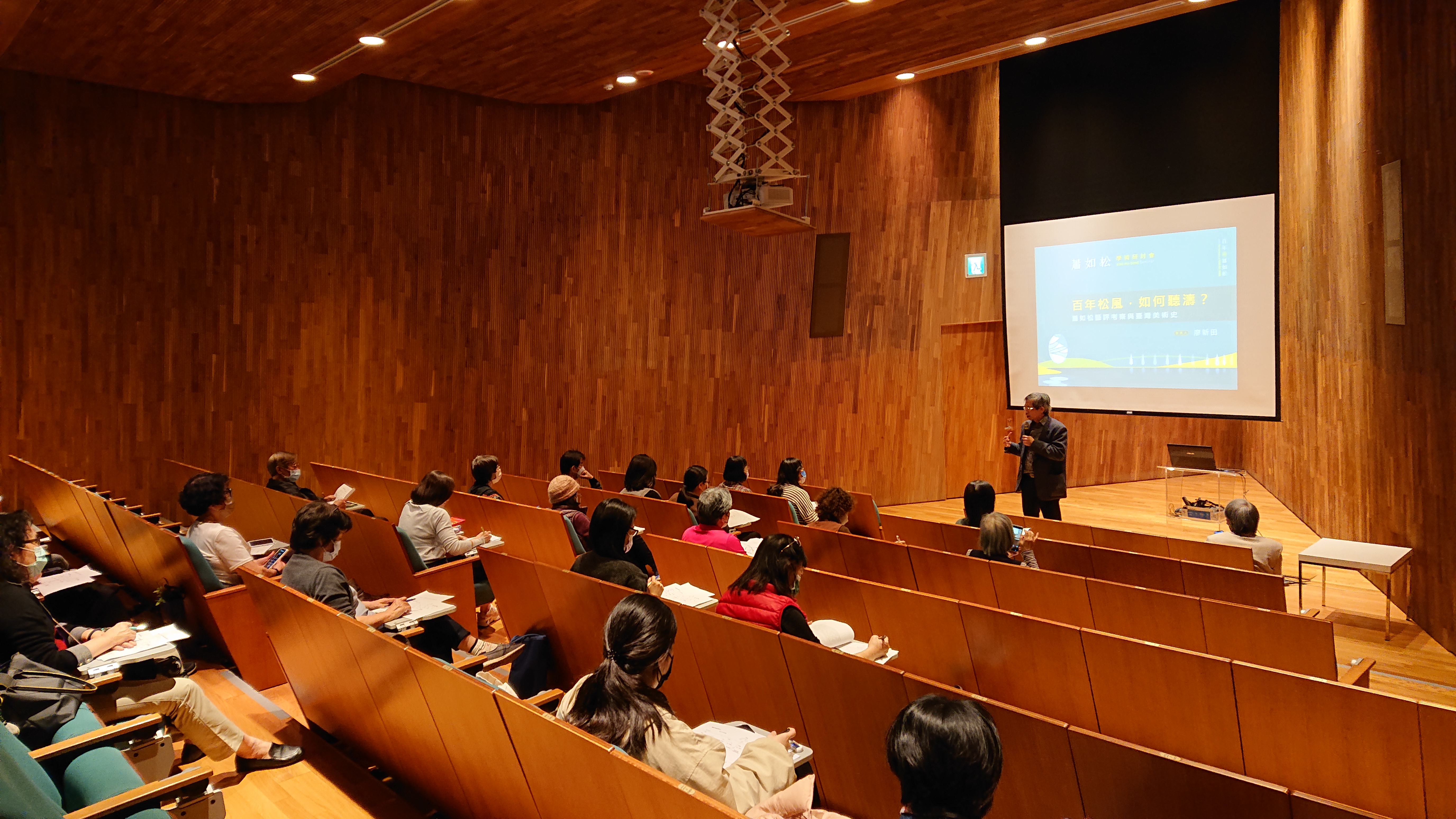 圖為廖新田教授(站立者)說，蕭如松作品明淨而富層次，帶來視覺的愉悅感和思考，為台灣水彩帶來新面貌。