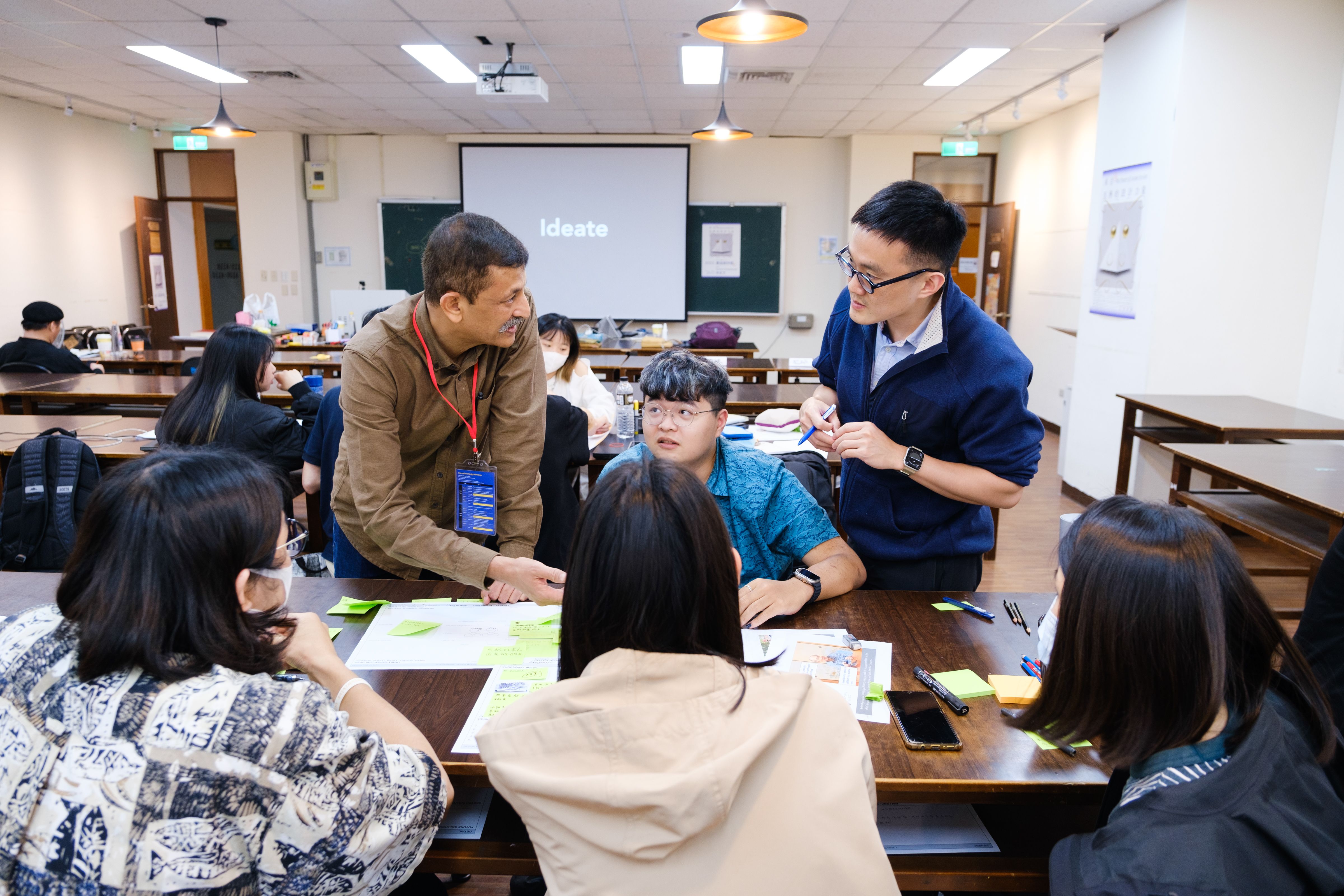 圖為印度設計大師Ashish Deshpande (站立者左)，與學員討論創作方向。